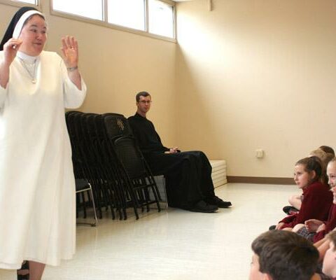Sister Mary Clare Bezner, OSB, (left) shares a story with students from Christ the King in Little Rock during the May 2016 Vocations Day for Catholic school students. Brother Raban Heyer, OSB, (seated center) also talked about his life to this and other groups during the day along with priests, seminarians and members of other religious orders. Fifth graders in Catholic schools will get their own Vocations Day once again April 26, after a three-year pandemic break.