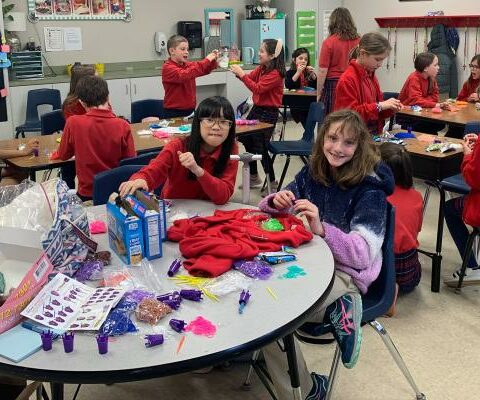 The Bracelet Club founder Mary Elizabeth Hiebert (foreground right) and 23 other St. Joseph School students meet April 24 to make bracelets for Highlands Oncology in Springdale.