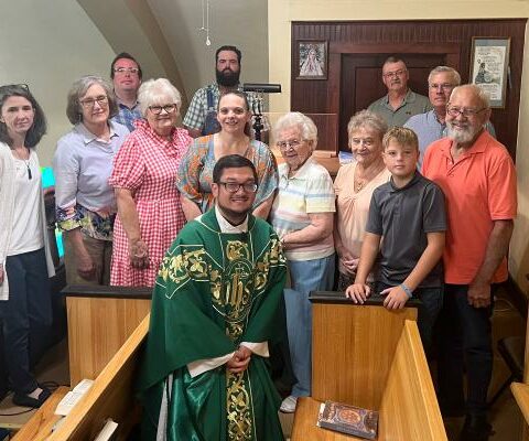 Members of the choir at St. John the Baptist Church in Engelberg gather around Father Stephen Elser after performing at Mass Aug. 20.