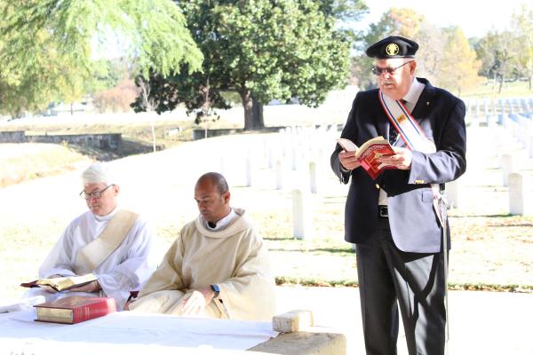 Knight of Columbus member Alan Carlson (right) lectors during the Veterans Day Mass Nov. 11 at the Little Rock National Cemetery, celebrated by Father Bhaskar Malapolu. Deacon Jim Goodhart (left) assisted.