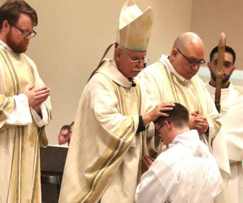 Deacon Joel Brackett (kneeling) is prayed over by Bishop Anthony B. Taylor during his diaconate ordination Mass May 15 at St. Vincent de Paul Church in Rogers. (Alesia Schaefer)
