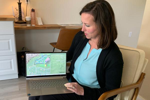 Errin Stanger, founder and CEO of Providence Park, shows Arkansas Catholic development plans for Providence Park from inside a tiny home model June 4. (Katie Zakrzewski)