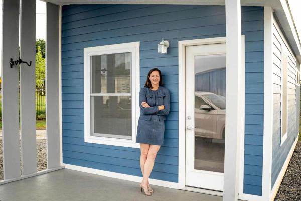 Errin Stanger, founder and CEO of homeless housing village Providence Park, stands on the front porch of one of the tiny home models that will be built in Little Rock. (Courtesy Errin Stanger)